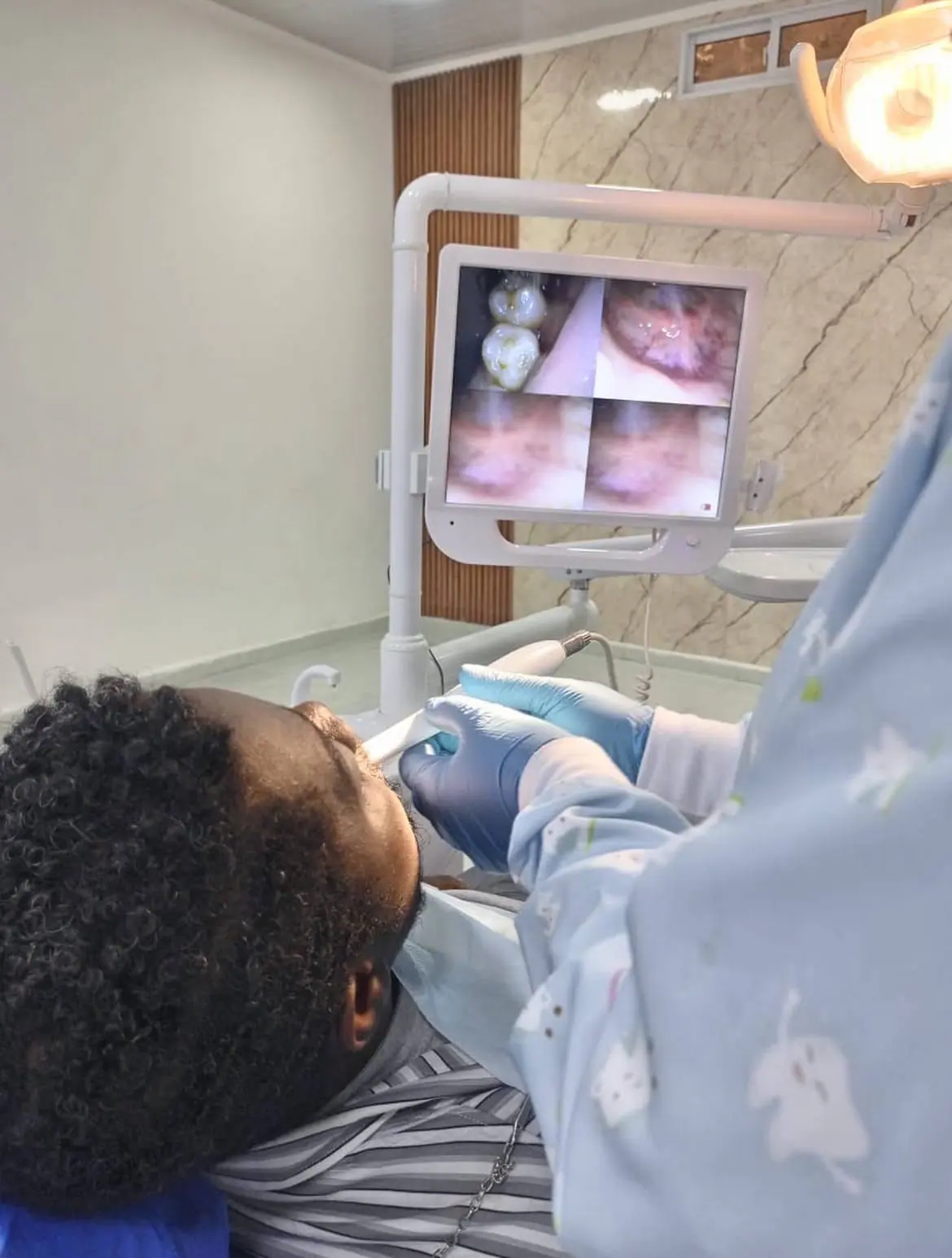 Profissional da Dental Med realizando avaliação dentária com apoio de imagem